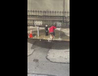 Man red shirt brush foot at fire hydrant