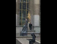 Couple poses beside the golden statue at snowstorm