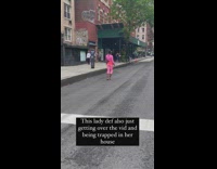 Woman in pink outfit dancing on street to music