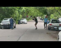 Guy lays down on car and pushes against it for video 