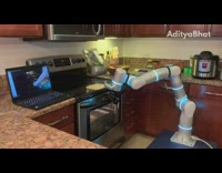 Robot arm opens oven door kitchen laptop 