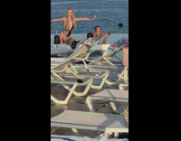 Guy selfie stick girl dances infinity pool 