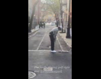 Man Plays Golf in an Alley Street 