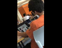 Guy watching inappropriate video orange shirt library