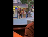 Two women tiktok dance on the sidewalk