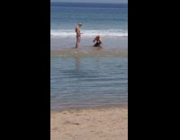 Man bury can beach sand woman pick up