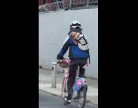Man rides bike with dog on carrier