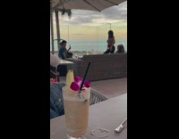 Woman in tank top poses in front of two kids at the balcony