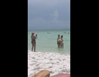 Two girls bikini hug hit by wave