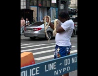 Man standing holds two snake on arm 