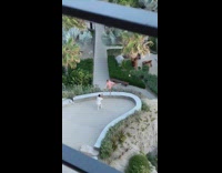 Woman pink dress raise legs arms park