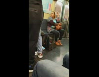 Woman face palms and gets annoyed by music playing out loud on subway train