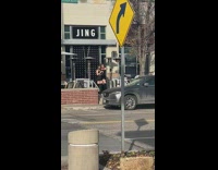 Two women in black dress tiktok dance in front of a store