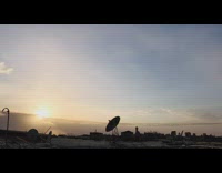 Time lapse of sunset satellite dish rooftop 