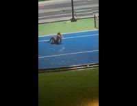 Woman spins around on wet tennis court
