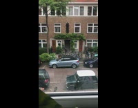 Woman black dress coat music video shoot sidewalk Part 2