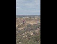2 women pose at Golden Bay hill 