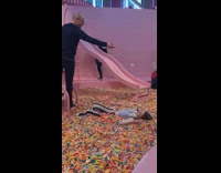 Girl lays in pool of sprinkles for photo