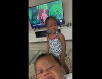Baby and toddler girls cry near tv 