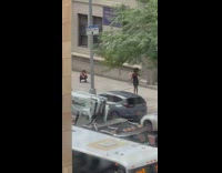 Woman in black dress poses and dances on the sidewalk