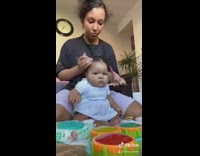 Woman mom does little baby hair pigtails 