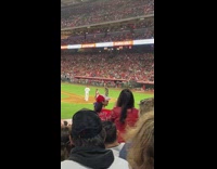 Woman in red jersey stands up and blocks the audience behind
