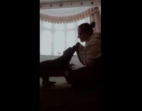 Woman sit on floor play with dog