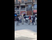 Woman stands on street barrier for photo