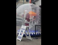 Santa Claus inside inflatable snow globe 