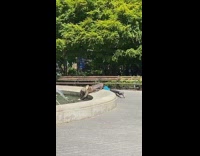 man large jacket boots bent over fountain
