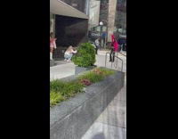 Woman in pink fur coat raises her hands in the air