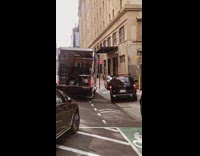 Several cars drive on sidewalk to go around truck