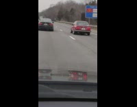 Photographer body outside window highway red car