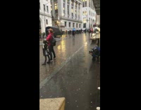 Person stands in rain for photo
