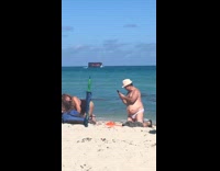 man takes picture womans butt beach