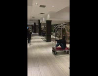 Woman records video riding a bellhop cart