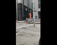 Woman in Orange Carries Large Balloons for Photo 