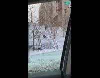 Boy rides mattress down snow covered stairs 