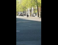 Girl rolls down street suitcase selfie stick 