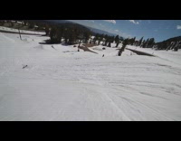 Snowboarder jumps off big hill and lands on side of board