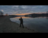 Guy walk beside lake with sunset reflection