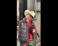 Young cowboy flicks his hat at the camera