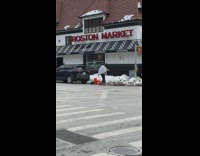 Guy plays trumpet outside Boston Market restaurant 