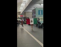 Woman in red dress carries Flag of Mexico