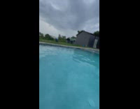 Dirt biker jumps and lands over long swimming pool 