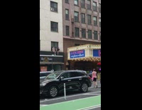 Two men sits on top of signage near Stephen Colbert sign