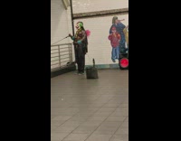 Oiled up man doing bicep curls for money at subway station