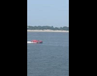Red car drives on top of bay