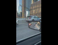 Aftermath of a car accident on a road surrounded by police officers 
