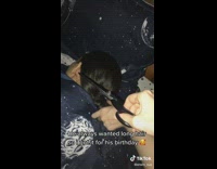 Cutting off hair of guy sleeping in bed space blanket 